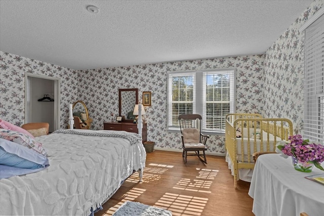 bedroom with hardwood / wood-style floors and a textured ceiling