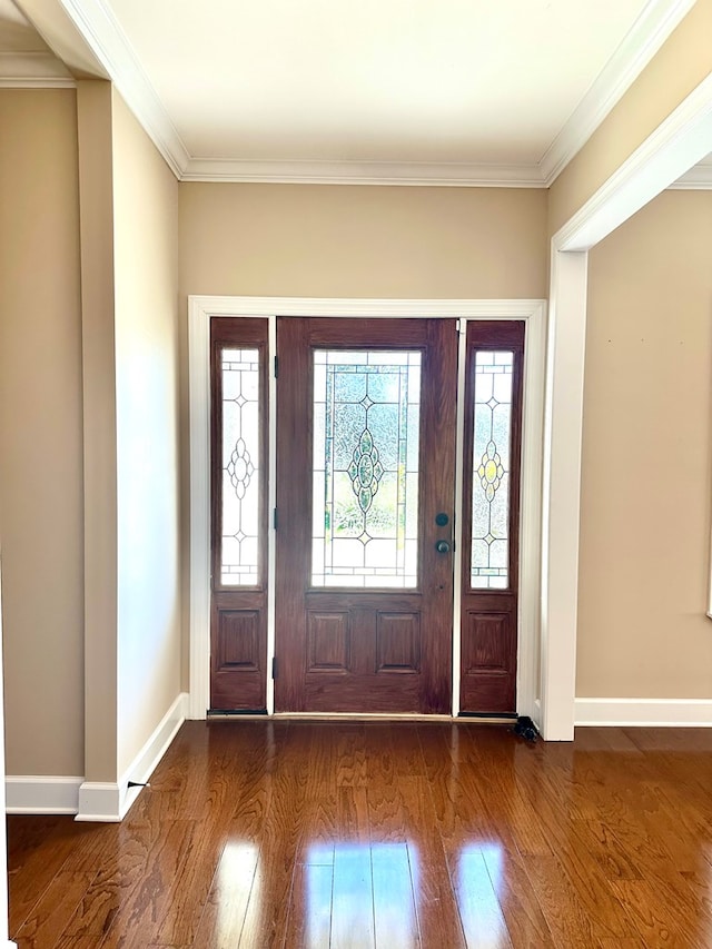 foyer entrance with hardwood / wood-style floors, crown molding, and baseboards