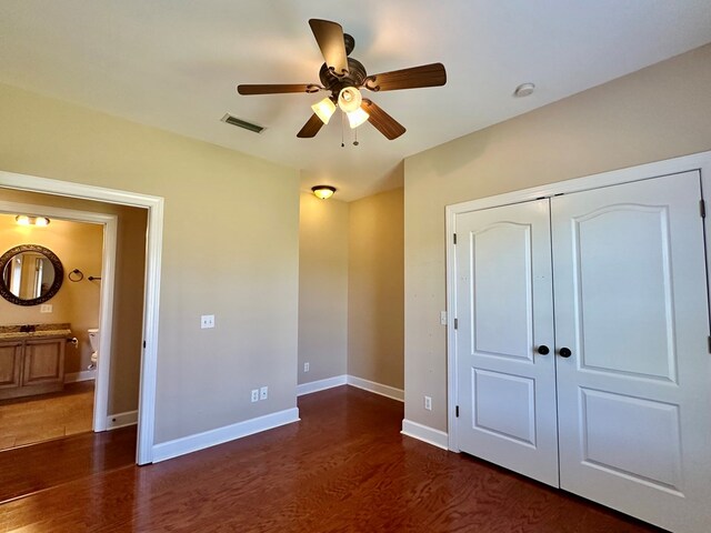 unfurnished bedroom with wood finished floors, visible vents, baseboards, ceiling fan, and a closet