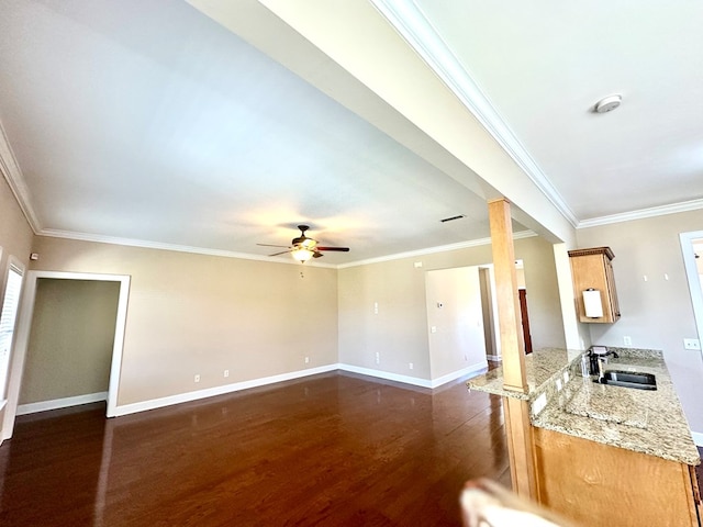 unfurnished living room featuring crown molding, ceiling fan, baseboards, dark wood finished floors, and a sink