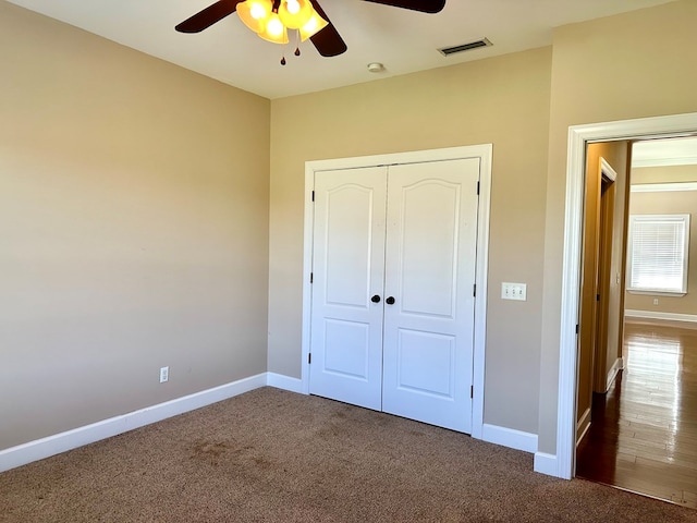 unfurnished bedroom with visible vents, carpet, and baseboards