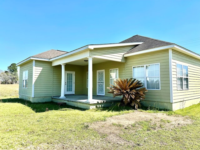 view of front of home with a porch, a shingled roof, and a front yard