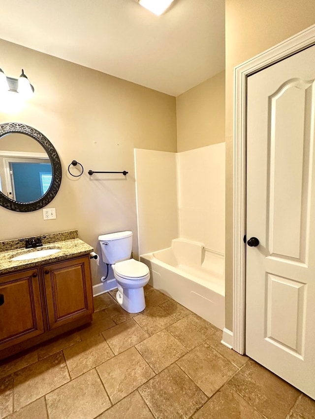 full bath with baseboards, toilet, stone tile flooring, and vanity