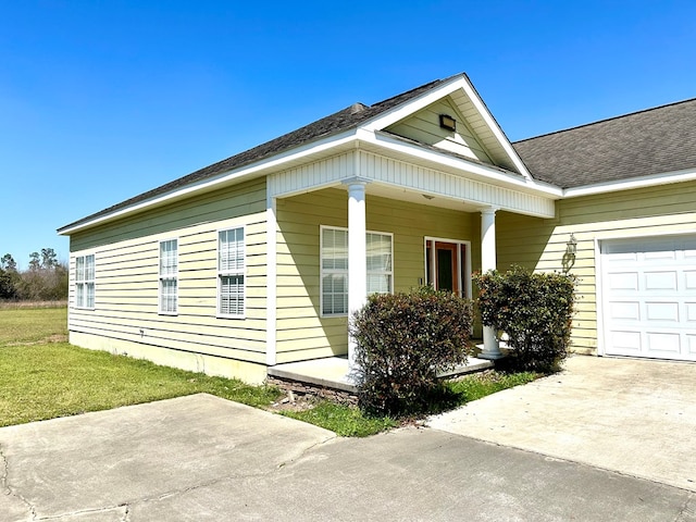 view of home's exterior with concrete driveway, covered porch, a garage, and a shingled roof