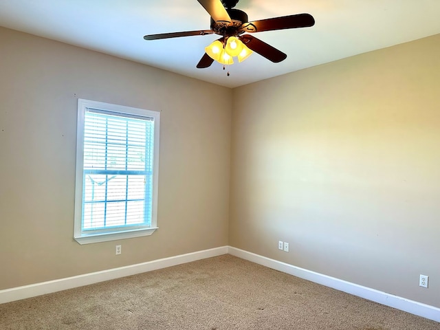 spare room featuring baseboards, light colored carpet, and a ceiling fan