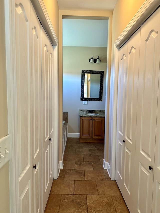 interior space with baseboards and stone tile flooring