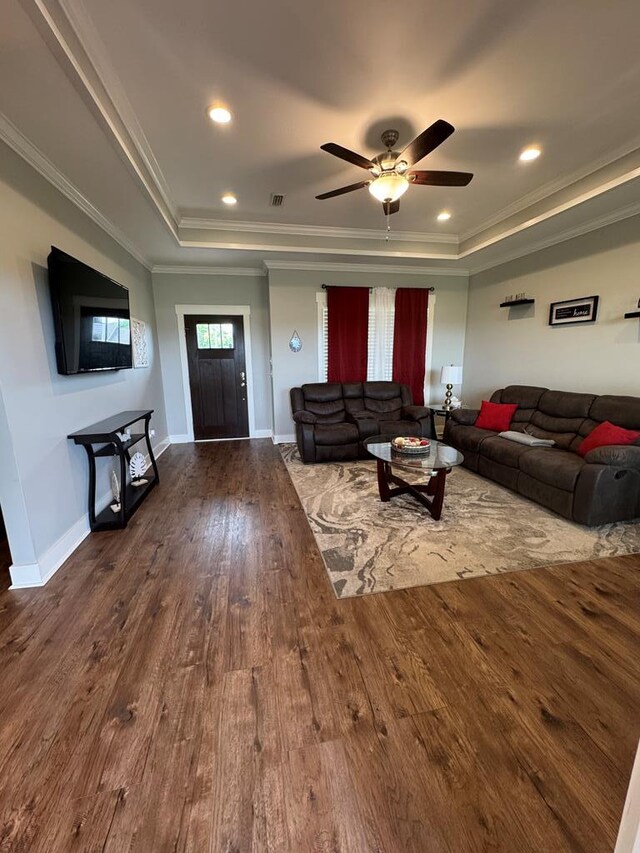 1180 Sandbed Rd, Newton, AL 36352 - living room featuring a raised ceiling, wood finished floors, crown molding, a ceiling fan, and baseboards