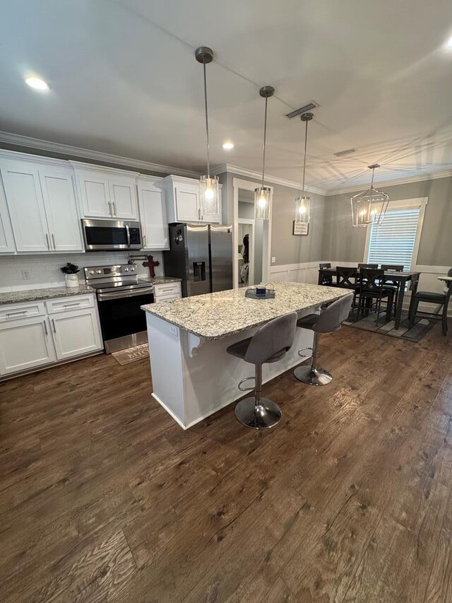 1180 Sandbed Rd, Newton, AL 36352 - kitchen with stainless steel appliances, ornamental molding, a breakfast bar area, white cabinets, and a kitchen island