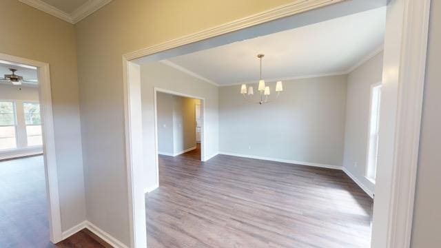 unfurnished dining area featuring wood-type flooring, ceiling fan with notable chandelier, and ornamental molding