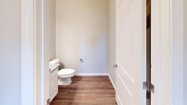 bathroom with hardwood / wood-style floors, vanity, and toilet