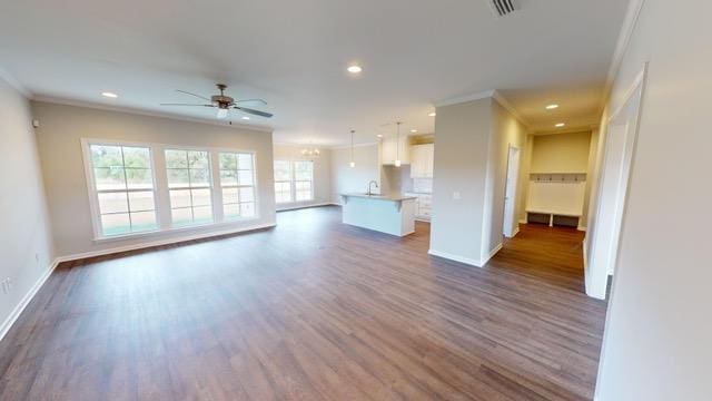 unfurnished living room with dark hardwood / wood-style flooring, ceiling fan, and ornamental molding