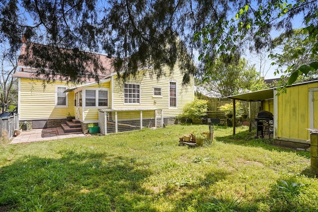 back of house featuring a lawn, fence, and entry steps