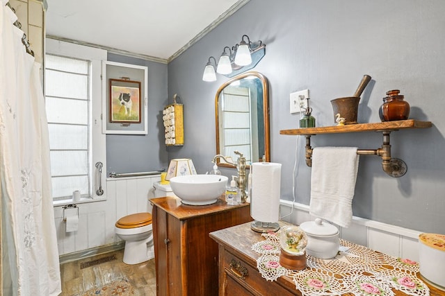 full bath featuring a wainscoted wall, visible vents, toilet, wood finished floors, and vanity