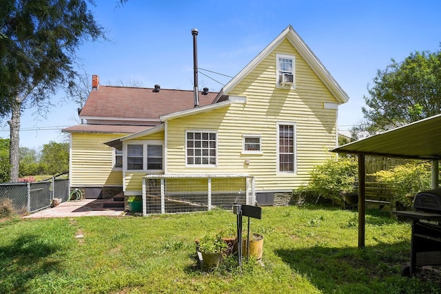 rear view of house featuring a patio area, a lawn, and fence