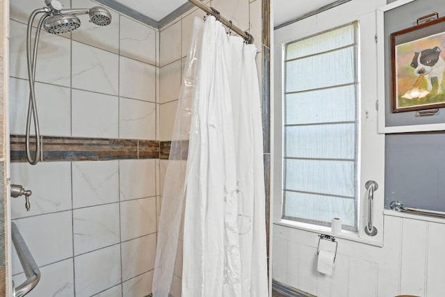 bathroom with tiled shower and plenty of natural light
