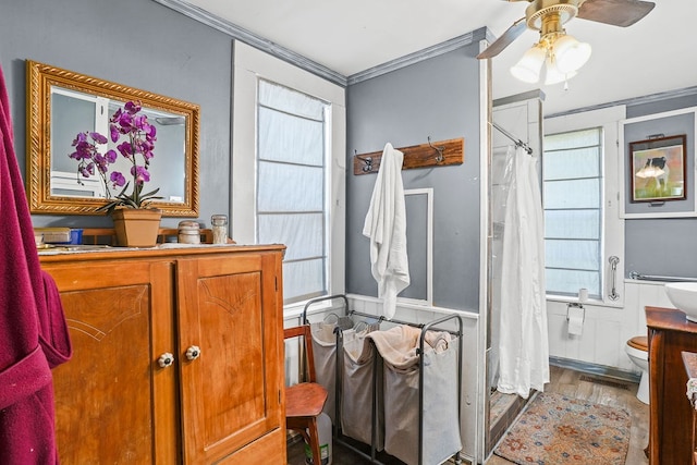 full bathroom featuring vanity, a shower with curtain, wood finished floors, ceiling fan, and ornamental molding