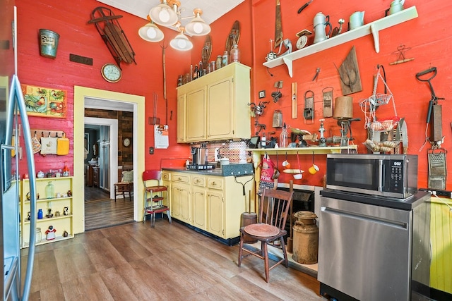 kitchen featuring open shelves, stainless steel appliances, a high ceiling, dark countertops, and wood finished floors
