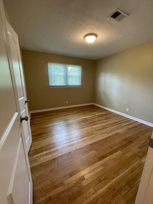 1103 Sassar St, Dothan, AL 36301 - spare room featuring a textured ceiling, hardwood / wood-style floors, and baseboards