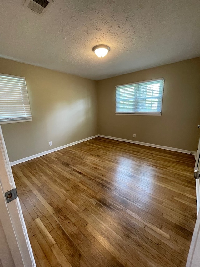 1103 Sassar St, Dothan, AL 36301 - spare room featuring a textured ceiling, wood finished floors, and baseboards