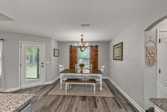 dining area with a healthy amount of sunlight, arched walkways, dark wood-type flooring, and visible vents