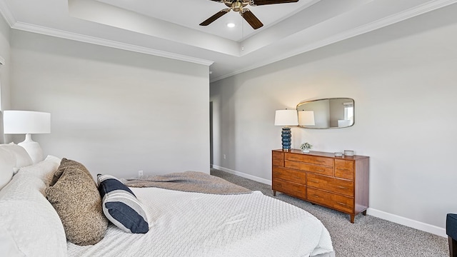 carpeted bedroom featuring a tray ceiling, ceiling fan, and ornamental molding