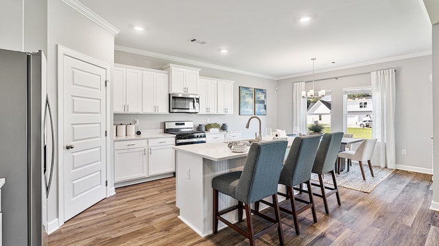 kitchen featuring stainless steel appliances, white cabinetry, a kitchen island with sink, and dark hardwood / wood-style floors