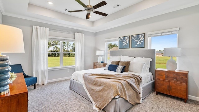 bedroom with a raised ceiling, ceiling fan, light colored carpet, and crown molding