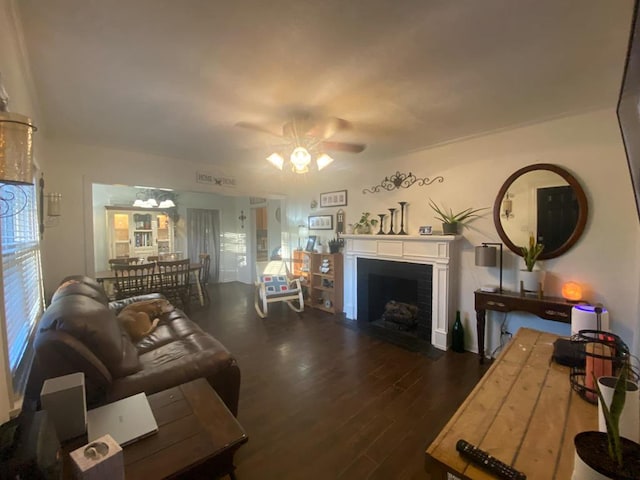 living area with a fireplace with flush hearth, wood finished floors, and a ceiling fan