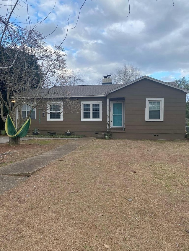 view of front of property featuring a front lawn, a chimney, and crawl space