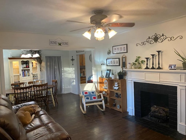 living area featuring crown molding, a fireplace with flush hearth, dark wood-style flooring, and ceiling fan