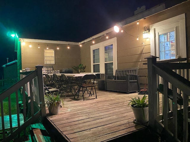 deck at night with outdoor dining area