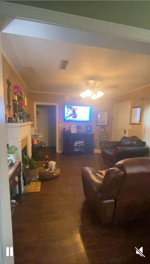 living room featuring visible vents, ornamental molding, and a fireplace