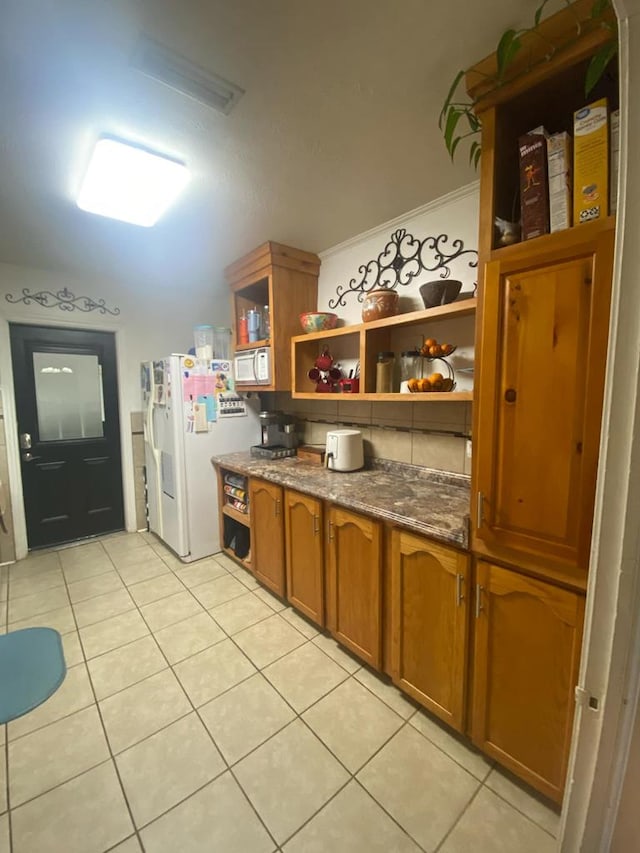 kitchen with light tile patterned floors, brown cabinets, white refrigerator with ice dispenser, and open shelves