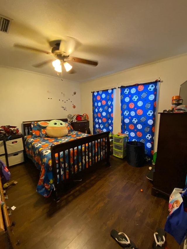 bedroom with ceiling fan, visible vents, and wood finished floors