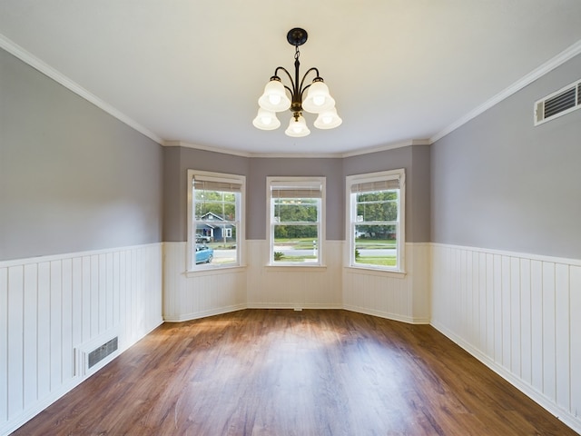 spare room with crown molding, dark wood-type flooring, and a notable chandelier