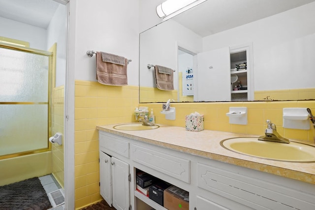 568 N Morris St, Slocomb, AL 36375 - full bathroom with tile walls, double vanity, combined bath / shower with glass door, and a wainscoted wall