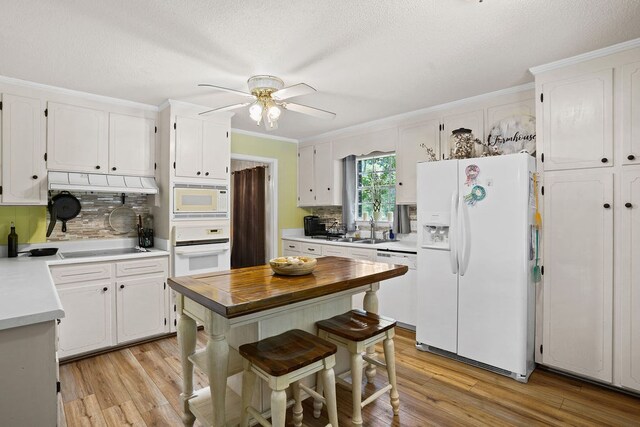 568 N Morris St, Slocomb, AL 36375 - kitchen featuring white appliances, white cabinets, ceiling fan, light wood-style floors, and crown molding