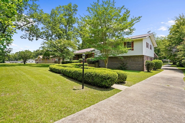 568 N Morris St, Slocomb, AL 36375 - view of side of property featuring brick siding, a lawn, and driveway
