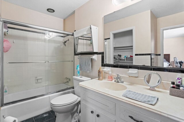 568 N Morris St, Slocomb, AL 36375 - full bath featuring vanity, shower / bath combination with glass door, toilet, tile walls, and tile patterned floors