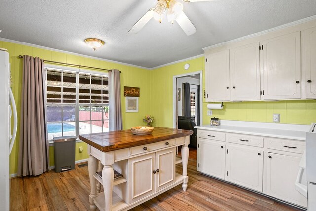 568 N Morris St, Slocomb, AL 36375 - kitchen featuring ornamental molding, white cabinetry, butcher block counters, wood finished floors, and a textured ceiling