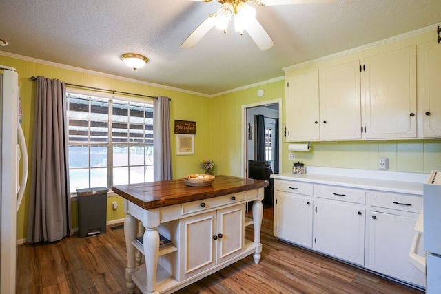 568 N Morris St, Slocomb, AL 36375 - kitchen with butcher block countertops, ornamental molding, white cabinetry, dark wood-style flooring, and a textured ceiling