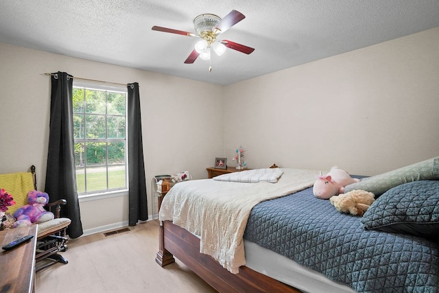568 N Morris St, Slocomb, AL 36375 - bedroom featuring light wood-style floors, baseboards, a ceiling fan, and a textured ceiling