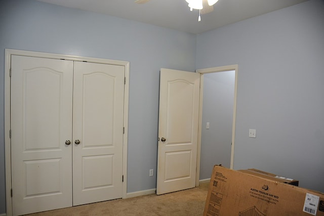 unfurnished bedroom featuring ceiling fan, a closet, and light colored carpet