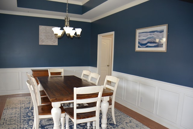 dining area featuring an inviting chandelier, light hardwood / wood-style floors, and ornamental molding