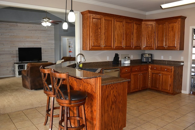 kitchen with dishwasher, sink, ornamental molding, kitchen peninsula, and a breakfast bar area