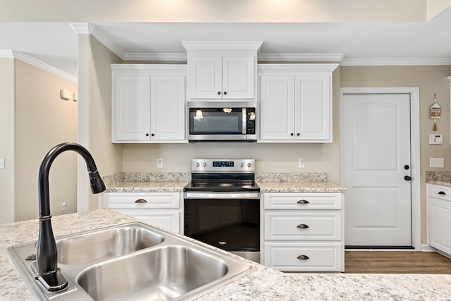 522 Birchwood Ln, Dothan, AL 36301 - kitchen featuring appliances with stainless steel finishes, a sink, white cabinets, wood finished floors, and ornamental molding
