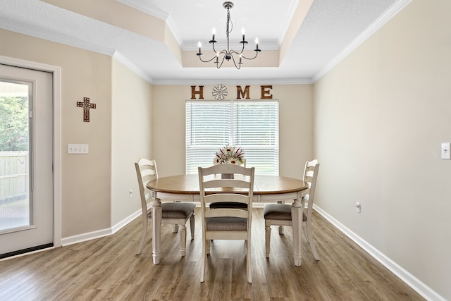 522 Birchwood Ln, Dothan, AL 36301 - dining space featuring a chandelier, wood finished floors, a tray ceiling, ornamental molding, and baseboards