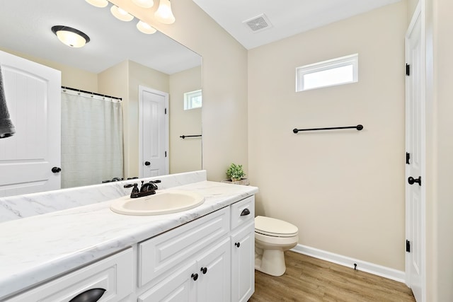 522 Birchwood Ln, Dothan, AL 36301 - full bath featuring vanity, wood finished floors, toilet, baseboards, and healthy amount of natural light