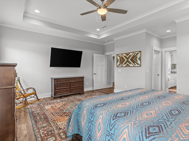 bedroom featuring crown molding, a raised ceiling, recessed lighting, and wood finished floors