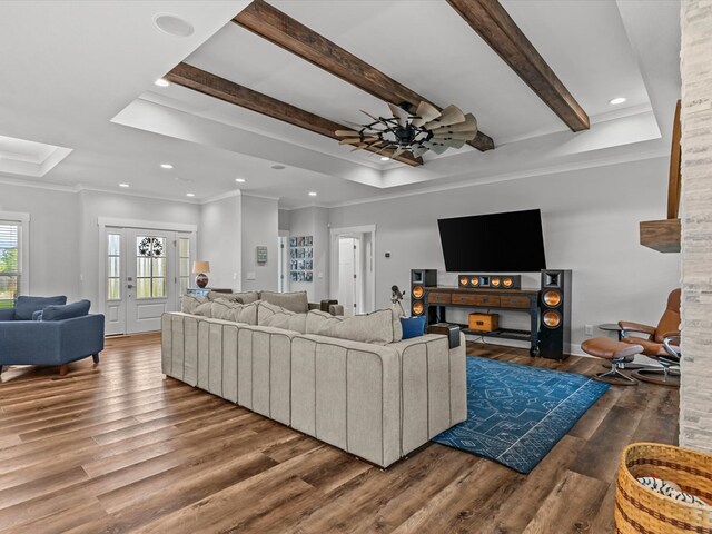living area featuring crown molding, wood finished floors, beamed ceiling, recessed lighting, and a raised ceiling
